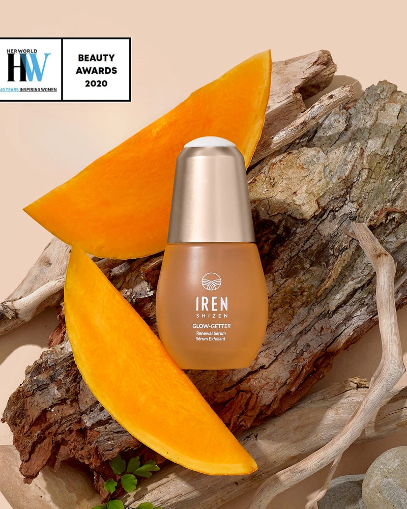 A bottle of IREN Shizen GLOW-GETTER Renewal Serum is shown on tree bark with pumpkin slices, beside a Health and Wellness Beauty Awards 2020 badge. #all-groups