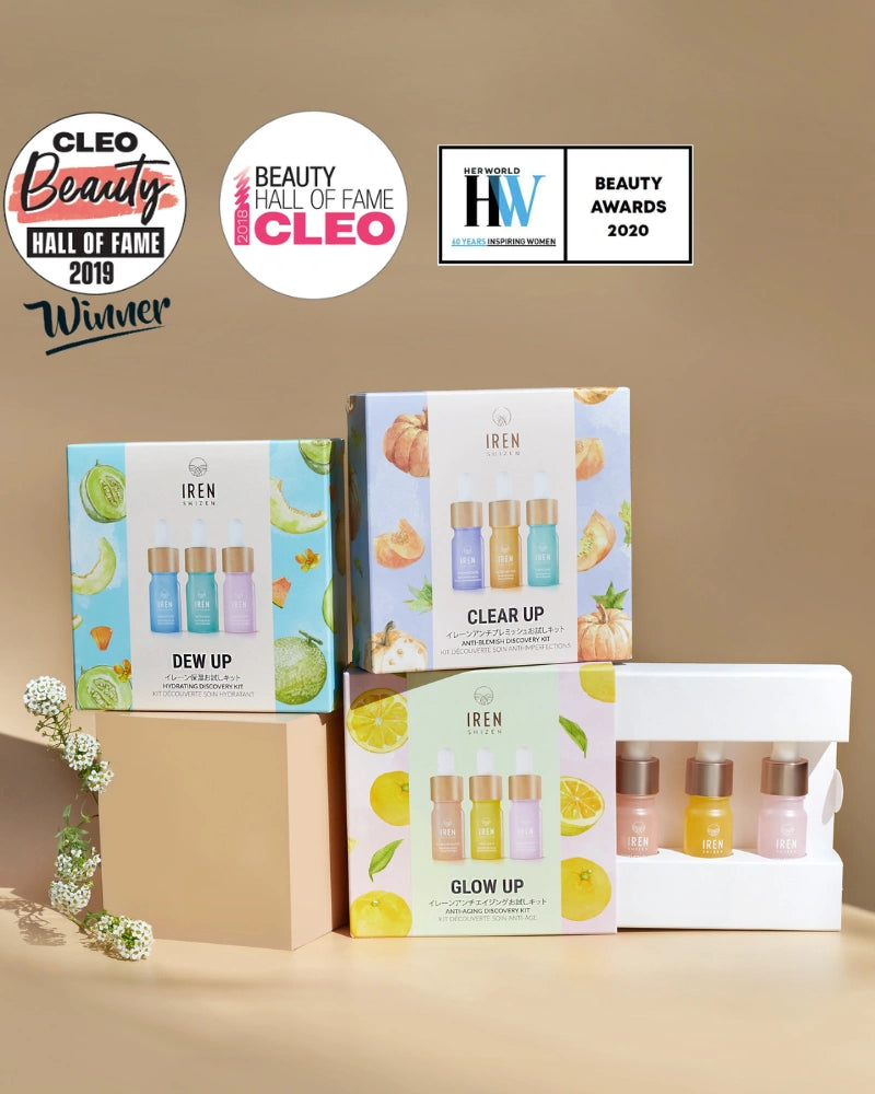 Three CLEAR UP Anti-Blemish Discovery Kits by IREN Shizen and a white tray of mini serums with Japanese superfruits are displayed on beige, with three beauty award badges above.