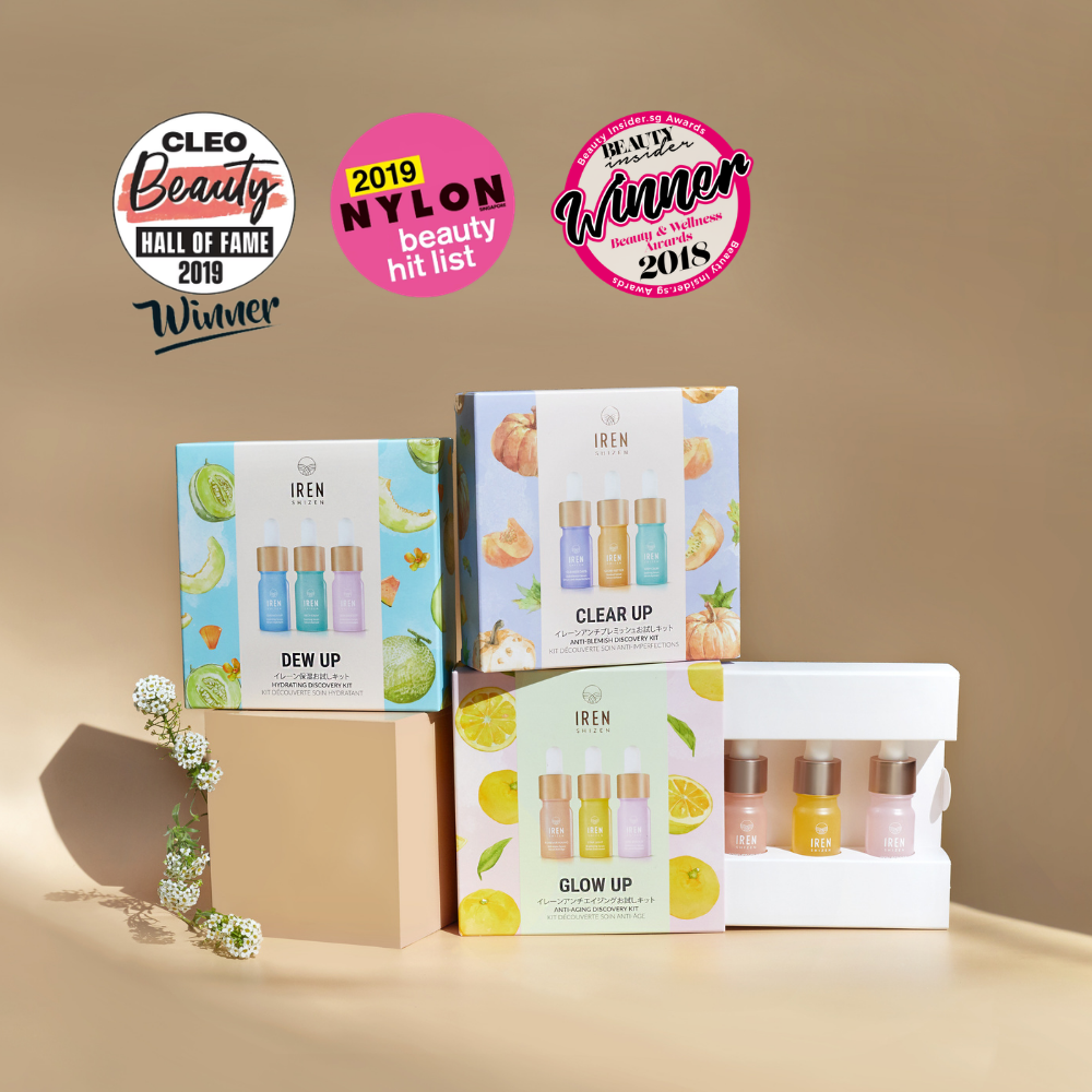 Three IREN Shizen DEW UP Hydrating Discovery Kits and a box of bottles, featuring hydrating serum for dewy skin, are displayed on a neutral surface with three beauty award badges in the background.