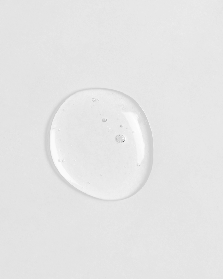 A small drop of custom skincare CLEAR UP Anti-Blemish Discovery Kit by IREN Shizen on a white surface.
