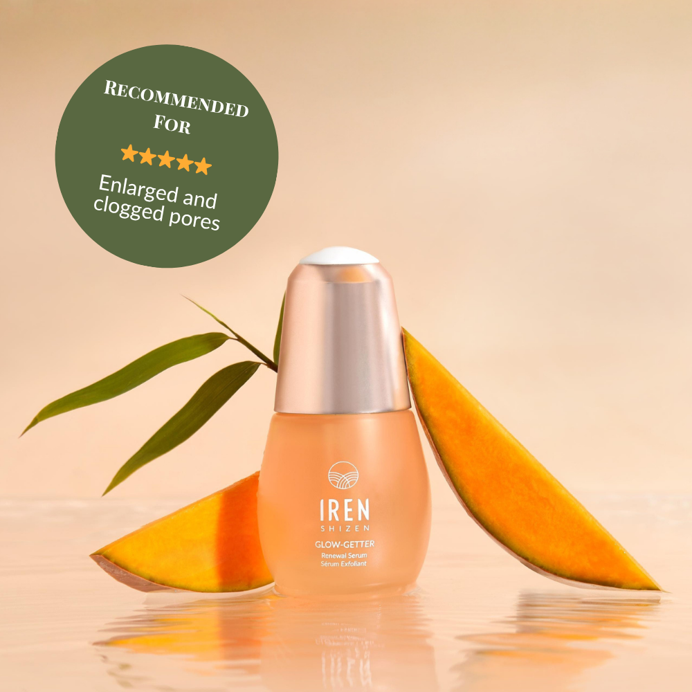 A bottle of IRÉN Shizen GLOW-GETTER Renewal Serum is shown with mango slices and a leaf, with a label recommending it to exfoliate and reduce blackheads for enlarged or clogged pores. #show-lang-en