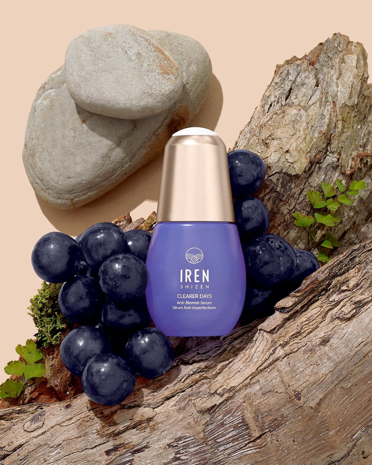 A bottle of CLEARER DAYS Anti-Blemish Serum with grapes and grapes on top of a piece of wood, showcasing Japanese skincare. #all-groups