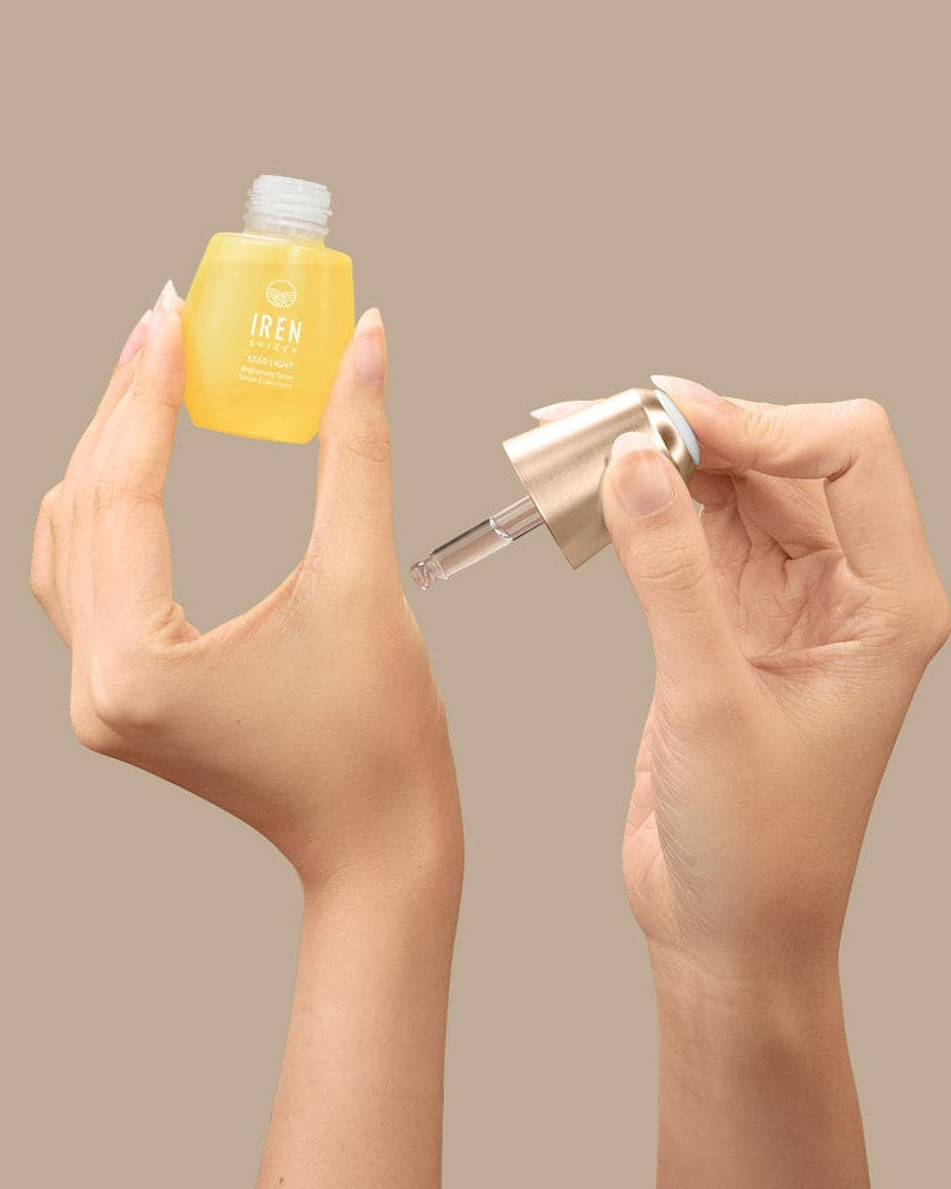 A woman's hands holding a small bottle of customised IREN Shizen STAR LIGHT Brightening Serum. #all-groups