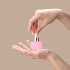 A woman's hand holding a firm BLOOM OF YOUTH Restoring Facial Oil bottle by IREN Shizen. all-groups