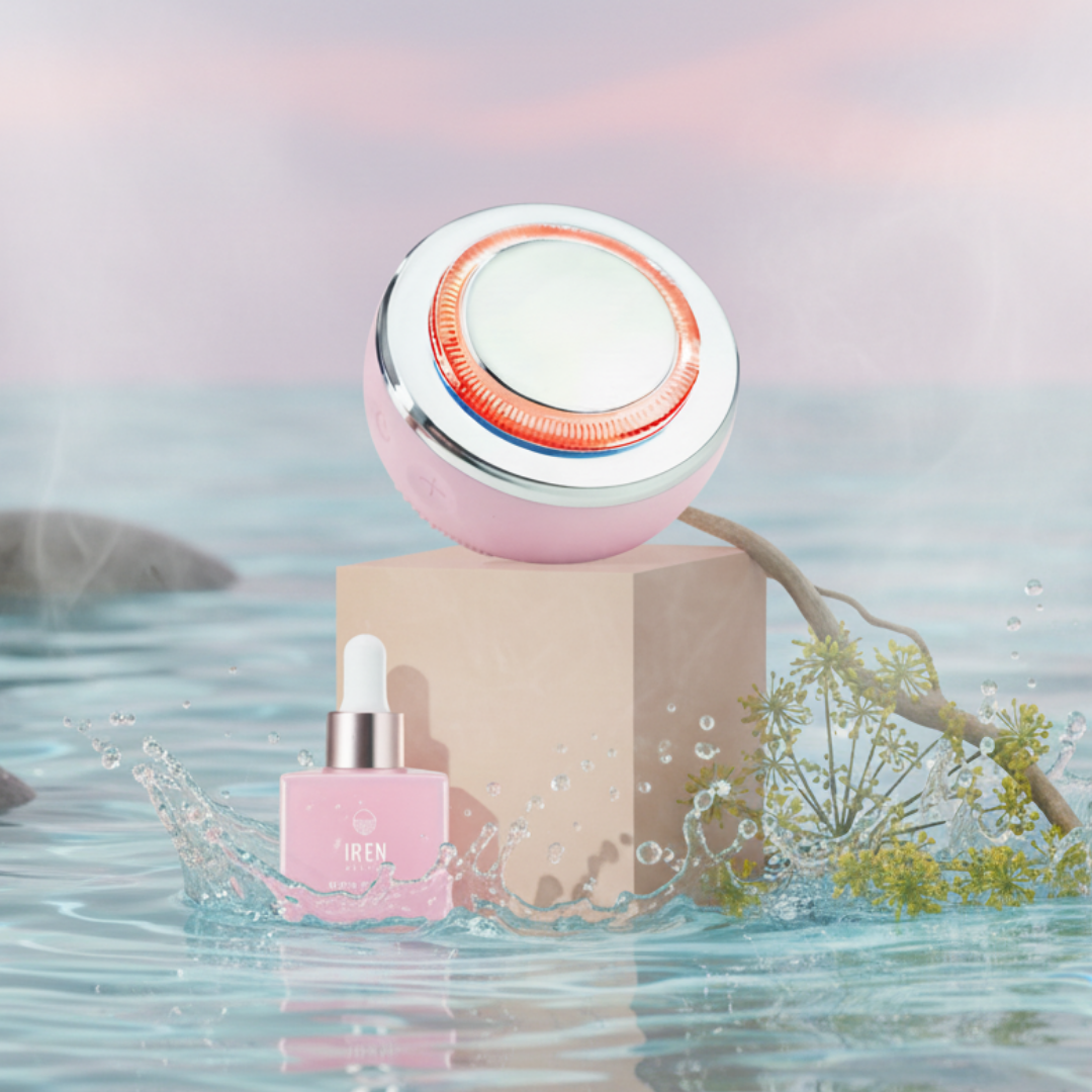 The SKIN GENIE PRO Hydration Set by Fast Bundle, featuring a pink dropper bottle and facial cleansing device, rests on a beige block amid water, a branch, and light mist beneath a pastel sky.