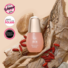 A bottle of IREN Shizen FOREVER YOUNG Anti-Aging Serum rests on wood and rocks, surrounded by goji berries. Three beauty award badges on the left highlight its collagen-boosting and anti-aging benefits.