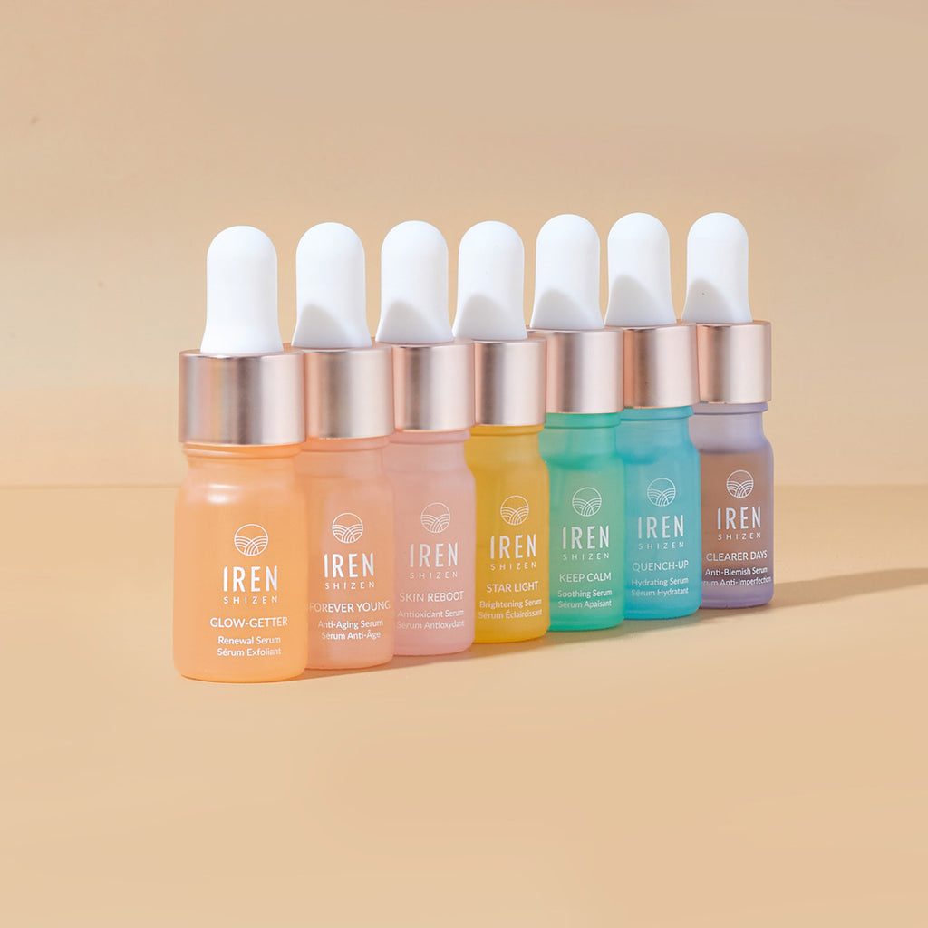 A set of DEW UP Hydrating Discovery Kits with different colored liquids on a beige background from the Japanese skincare brand IREN Shizen.