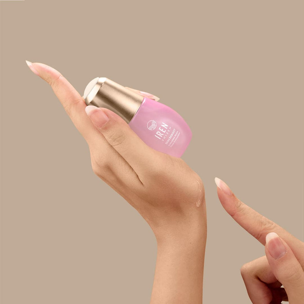 A woman's hand holding a bottle of Japanese customised skincare by IREN Shizen.