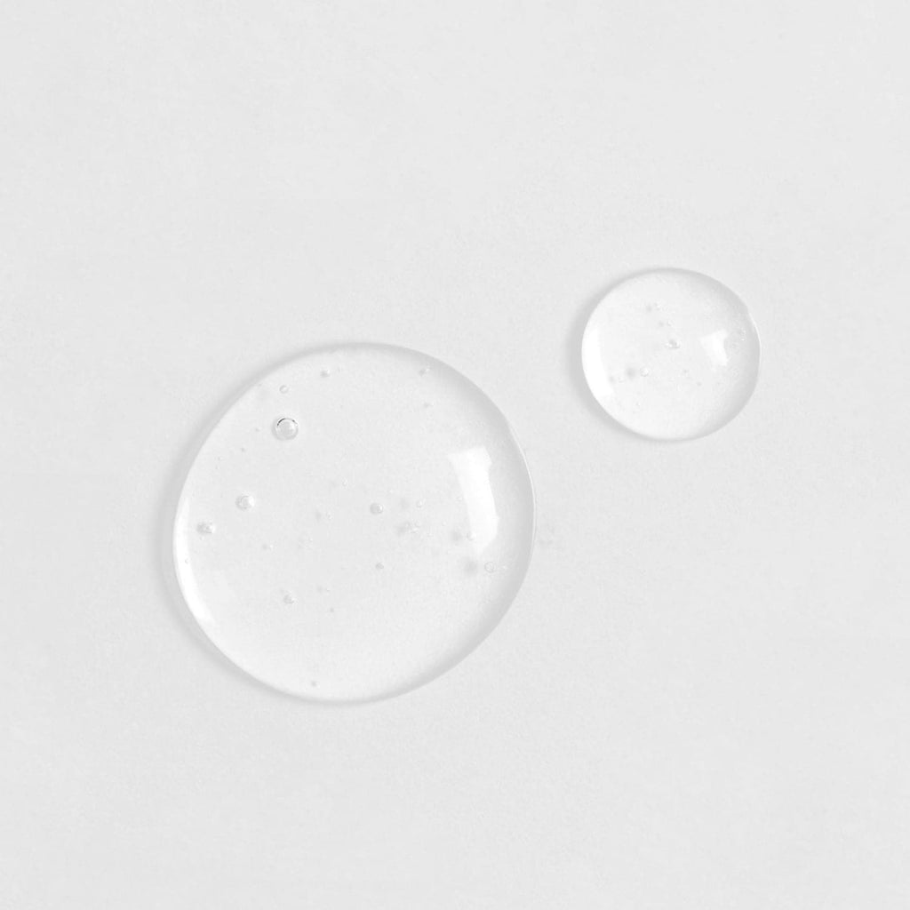 Two Japanese QUENCH-UP Hydrating Serum drops on a white surface.