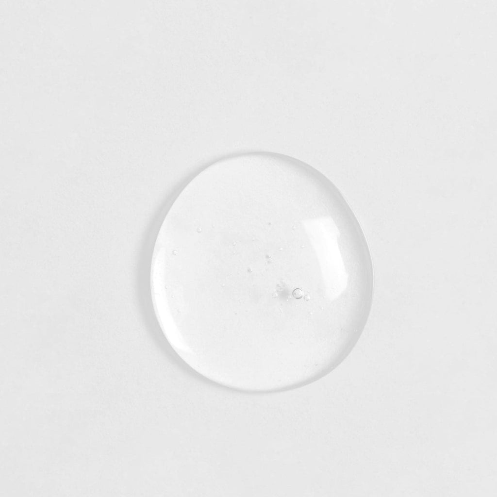 A clear glass ball of customised SKIN REBOOT Antioxidant Serum on a white surface by IREN Shizen.