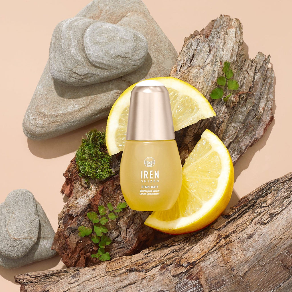 A bottle of customised STAR LIGHT Brightening Serum by IREN Shizen on a rock.